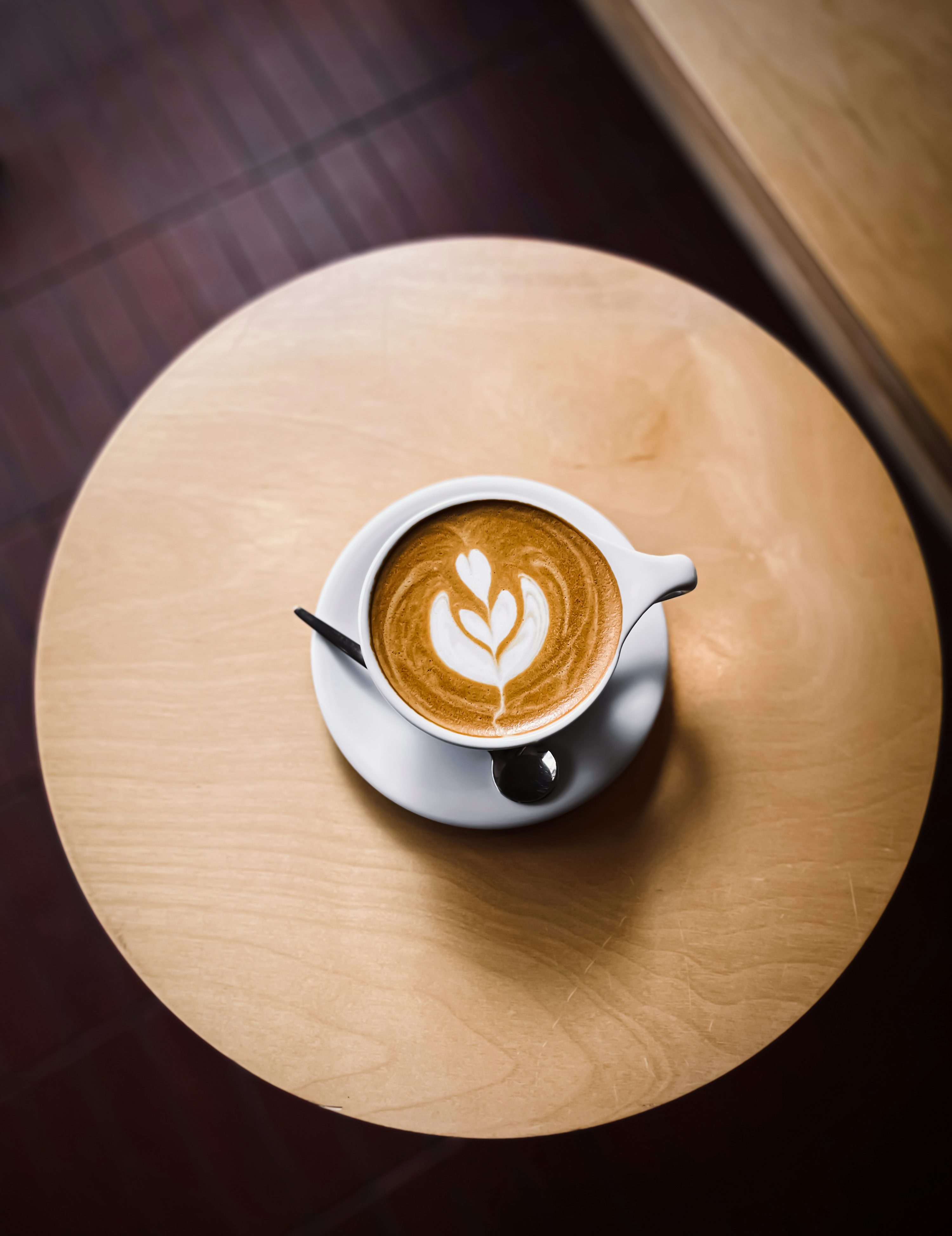 Overhead shot of latte art on wooden table